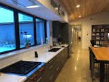 Kitchen, Ceiling Lighting, Refrigerator, Engineered Quartz Counter, Subway Tile Backsplashe, Pendant Lighting, Cooktops, Colorful Cabinet, Concrete Floor, and Undermount Sink  Photo 6 of 10 in The Martinson House by scott martinson