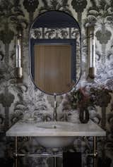 Extravagant, black and white wallpaper adds fun detailing to this powder room.