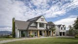 Large windows, wooden pillars and large sliding doors make this house feel open and light without sacrificing the traditional exterior shapes and angles.