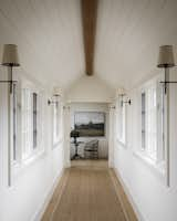 This long and narrow hallway is instantly brightened up with the strategic placing of windows and tall ceilings—all painted/framed in shades of ivory.