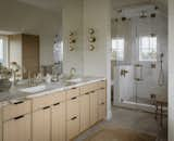 The primary bath is spacious and bright in various shades of beige and white.