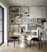 This unique, monochromatic gallery wall adds personality and charm to this dining space.