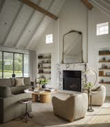 Tall arched ceilings, exposed wooden beams, large glass sliding doors and a marble fireplace re some of our favorite details in the main living space.