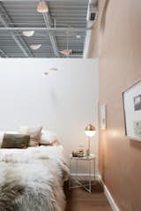 A Flensted mobile hangs over the bed. The terra cotta wall continues over the half wall into the dining area.  Photo 4 of 19 in Nolan and Penelope's Dining Loft by Nolan Beck-Rivera