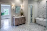 Bath Room, Marble Counter, Open Shower, Ceiling Lighting, One Piece Toilet, Corner Shower, Full Shower, Marble Floor, Wall Lighting, Freestanding Tub, Marble Wall, Undermount Sink, Enclosed Shower, and Soaking Tub Master Bath/Closet  Photo 9 of 17 in Liberty Manor by Historic Savannah Homes By Liza DiMarco