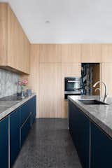 Stone and timber against navy colored kitchen joinery in Westbourne Cottage