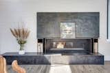 Dramatic steel panels slide open to reveal the TV over the long fireplace and steel mantel