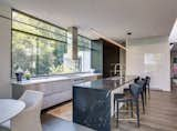 Kitchen, Granite Counter, Refrigerator, Metal Cabinet, Range, Undermount Sink, Cooktops, Dark Hardwood Floor, Range Hood, White Cabinet, Wall Oven, Pendant Lighting, and Marble Counter  Photo 12 of 15 in Modern View by Bradley Glenn Norris