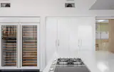 Kitchen equipped with waterfall quartz countertop and wine fridge. 