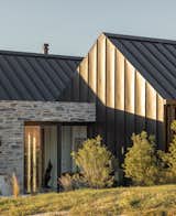 Stone entry area connects metal-clad gabled forms