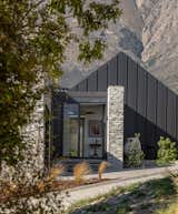 Local schist stone blade wall defines the home's entrance