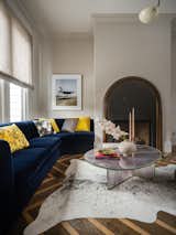 Living Room Area (detail): a custom, deep blue/ink museum mohair sofa and custom “salt & pepper” hair-on-hide area rug grounds the room; photograph on wall by Tim Walker.