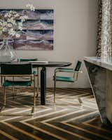 Dining Room Area: a bold and edgy chevron flooring — with alternating dark and light wood, in both wide and thick planks — creates a striking dialog with the patterned linen drapery, Ellipse dining table, and vintage 1970s French armchairs.