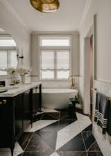 A dreamy, light-filled nook was the perfect spot for an equally dreamy Blu-Stone freestanding soaking tub in the Primary Bath. Custom mahogany vanity with a Calacatta Oro marble top; Calacatta, Emperador, and Nero Marquina marble flooring in a custom geometric pattern.