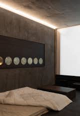 Brass accents against pigmented cement walls in the entertainment room