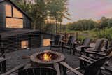 Just a few more steps up a ridge in the backyard is a large fire pit surrounded with Adirondack chairs for your entire group to gather around.