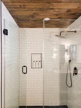 Classic tile in our bathrooms, but elevated with the warm wood stretching across the ceiling.