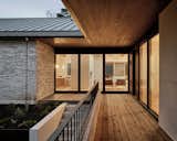 Exterior, Metal Roof Material, House Building Type, Gable RoofLine, Brick Siding Material, and Stucco Siding Material Cedar deck at front entry  Photo 5 of 7 in NW Hills Residence by Hunt Architecture