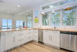 Kitchen, Wood Counter, Pendant Lighting, Dishwasher, White Cabinet, Undermount Sink, and Light Hardwood Floor  Photo 16 of 21 in MCM Cottage by Carol Genzink