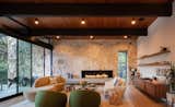 The living room of the Crosby Home is a sanctuary for family and friends to gather. Using natural materials in interior spaces is iconic mid-century modern design: a groutless stone wall, exposed beams, wood paneled ceilings, and a concrete and steel fireplace create the perfect environment to relax and leave the stresses of everyday life behind.