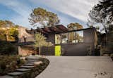 Dark tones contrast with lights in this spectacular design. With all of its beauty, the home is still wildly sustainable. Drought-tolerant landscaping is used to lower the water usage while large windows let in an abundance of natural light. Retractable glass walls bring continuity from the exterior to the interior and allow for passive ventilation into the home, A balcony overlooking the front yard serves as a great spot to watch sunsets and have outdoor summer meals with family and friends. 