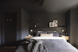 he primary bedroom features a low bed and lighting by Montreal brand Luminaire Authentik