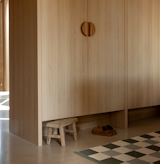 Mudroom entry with shoe kick-off storage below jacket cabinets