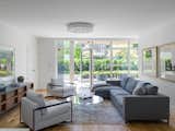 Sunny living area with floor-t0-ceiling glass doors and windows.