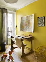 Local architect Sophie Dries combined two Haussmann apartments in Paris’s Marais district to create a larger, open space for a young family. Impactful paint colors and contemporary art counterbalance the delicate architecture and vintage furnishings throughout the home. In the children’s playroom, a piece by JonOne hangs alongside a vintage map on an acidic yellow wall.