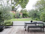 Outdoor, Shrubs, Back Yard, Small Patio, Porch, Deck, Trees, Garden, Hardscapes, Gardens, Grass, and Decking Patio, Porch, Deck  Photo 1 of 28 in Landscaping by Jo terkel from Black Pivot Doors Frame Views of This Australian Home’s Verdant Garden