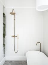 Bath Room, Ceramic Tile Floor, Ceiling Lighting, Freestanding Tub, Pendant Lighting, Open Shower, and Accent Lighting  Photos from Black Pivot Doors Frame Views of This Australian Home’s Verdant Garden
