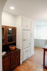 Kitchen, Refrigerator, Colorful Cabinet, Marble Counter, White Cabinet, Wood Cabinet, Recessed Lighting, and Medium Hardwood Floor  Photo 3 of 6 in Cozy Cottage in North Carolina by Kendis Charles