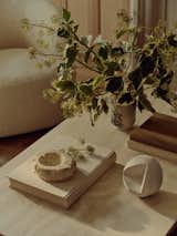 A collection of stone and ceramic objects rests on the living room’s Arhaus coffee table. They reflect the home’s focus on natural materials and a wabi-sabi aesthetic.
