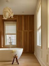 Mirei Monticelli’s Nebula suspension lamp presides above the primary bathroom’s Clovis Goods tub and Woodbridge filler. The Roman shades are from Pro Design.