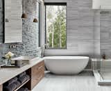 Bath Room, Enclosed Shower, Stone Tile Wall, Stone Slab Wall, Accent Lighting, Freestanding Tub, Corner Shower, and Pendant Lighting The modern gray palette is brought to life with warm wood hues and sleek finishes.  Photo 2 of 22 in Thunderhead Ski In, Ski Out by Britny Kalule