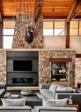 Douglas-fir timbers and a soaring pine ceiling give the home its modern mountain ethos, while a fireplace surrounded by waxed steel lends an industrial element.