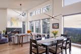 Dining Room, Accent Lighting, Pendant Lighting, Standard Layout Fireplace, Medium Hardwood Floor, and Table  Photo 9 of 17 in Hilltop House by Elizabeth Herrmann Architecture + Design