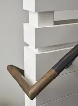 The steel handrails are capped with wood to soften the corner. 