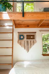 The bedroom nook features a hand-loomed tapestry by Jessica Sanchez, owner of Rusted Earth, a design studio and farm which produces sustainable, handcrafted home decor "from the soil up."