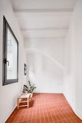 Hallway and Terra-cotta Tile Floor  Photo 15 of 17 in Picture Windows and Sliding Doors Work Magic in This Cozy Barcelona Home from The Akari House