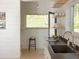 Kitchen, Drop In Sink, Pendant Lighting, Laminate Counter, Ceiling Lighting, Open Cabinet, White Cabinet, and Wood Cabinet  Photos from A Little Black Cabin Keeps Things Simple for a Family of Four in Vermont