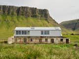 London- and Oslo-based architectural practice Studio Bua turned a battered 1930s farm building into a 1,959-square-foot live/work space in Iceland’s remote Breiðafjörður Nature Reserve.&nbsp;To contrast with—but not distract from—the rugged outbuildings and surrounding landscape, the team built a low-impact timber insert that allows the existing structure to maintain its distinctive character while adding another level to the home. The architects meticulously restored the original concrete structure, which was "fragile in some places," Sumarliðadóttir says, and lined the existing barn floor with a reinforced concrete raft.&nbsp;