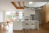 Kitchen, Laminate Counter, Drop In Sink, White Cabinet, Wood Counter, Ceiling Lighting, Light Hardwood Floor, and Refrigerator  Photo 10 of 32 in A Geometric Montreal Home Creates a Sense of Grandeur With a Small Footprint from Park Ex House