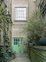 “The entrance is very unassuming,” says Jack. “It says ‘offices’ on the smaller building that faces the street, and the warehouse flats are set back. East London is quite busy, and walking in through the plant-filled courtyard makes our flat feel like a little oasis.”  Photo 1 of 9 in Fixture details by mary camacho from My House: A Filmmaker Couple Put a London Shoe Factory Back Into Production as Their Home and Studio