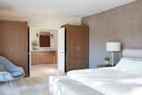 The wardrobes flanking the double doors to the bathroom match the wide double vanity in the bathroom.