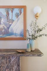 Lunt describes We had been searching for a piece for that spot for quite a while, and had already settled on the gorgeous antique John Hilton painting of a desert canyon waterfall with soft blues and creams, and this almost pearlescent plaster wallcovering. We happened upon the console in a vintage store in Palm Springs and it was just the perfect mix of elegance and the soft, pastel desert colors we were using in that space.