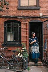 The kitchen door leads directly to the back easement garden. "We're always working on it," says Maureen.  It used to be a patch of dirt, but the couple opted to cover it over and create a container garden.  "Every year we change it a little. It's almost like a living room."   Photo 26 of 28 in My House: A Brooklyn Couple’s 1800s Townhome Melds Eras, Heirlooms, and Artwork