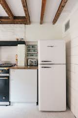 The refrigerator has vintage charm but is brand new, a Northstar by Elmira Stove Works. The hexagonal floor tile, also new, complements the original wood timber beams.