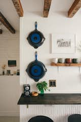 Hanging pots and open shelving add to the cottage styling, and provide attractive storage in the tiny kitchen. 