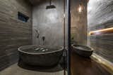 Bath Room, Concrete Counter, Concrete Floor, Ceiling Lighting, Vessel Sink, and Concrete Wall  Photo 15 of 16 in A Koi-Filled Moat Surrounds This Vietnamese House from Am house